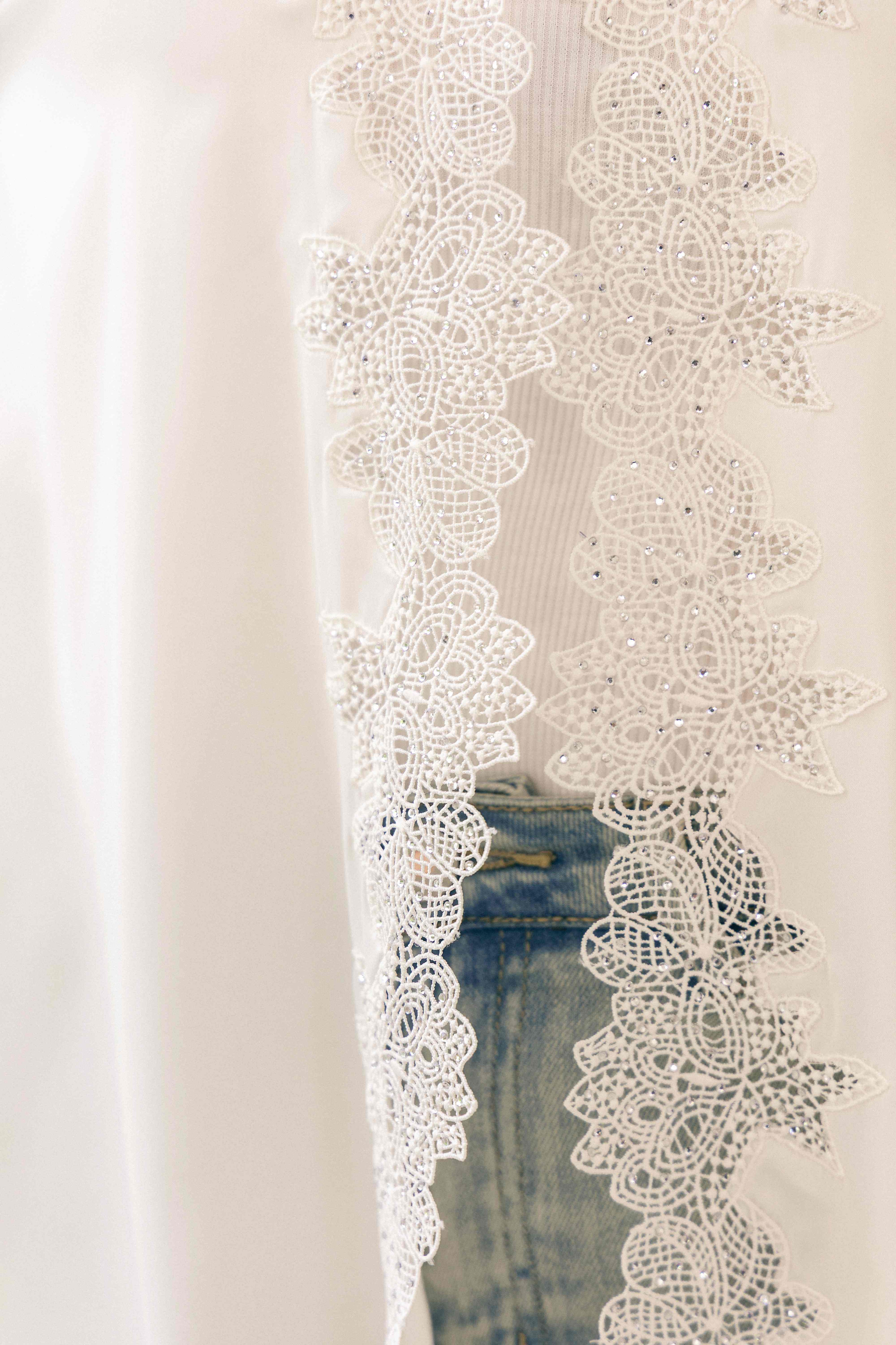 Macro detail of intricate lace and rhinestone work on Acetate fabric